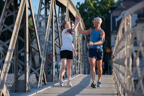 Walkers high fiving during a walk on a bridge