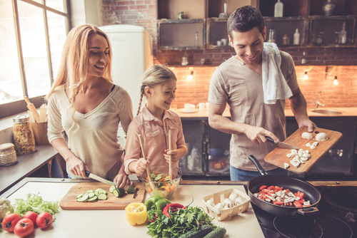 Family cooking dinner together in kitchen