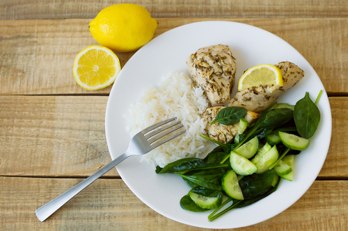 Healthy chicken vegetable and rice dinner with a lemon