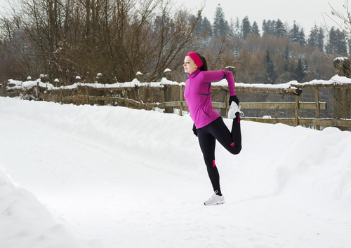 Woman stretching in snow