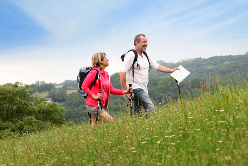 Couple hiking a hill with poles