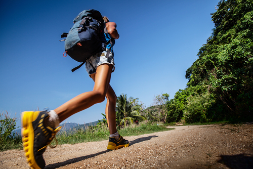 Woman incline hill walking with backpack