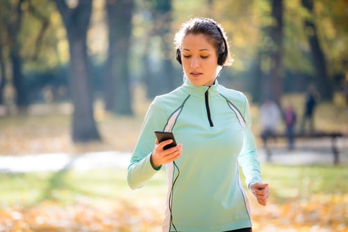 Active jogging woman checking phone