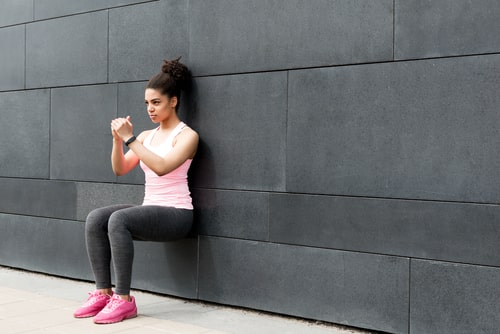 Woman doing a wall sit exercise