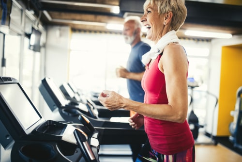 Senior couple walking on treadmills