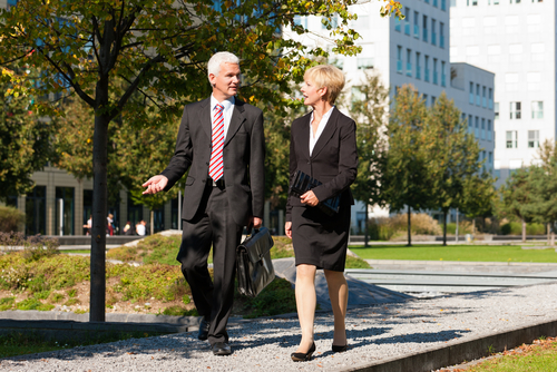 Older business people walking in a park