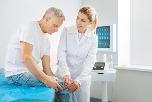 Doctor checking patient's knee