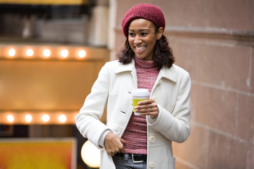 Woman holding coffee and smiling