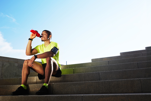 Man drinking a sports drink after a run