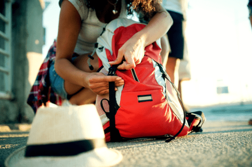 Woman packing a backpack and hat for a nice hike