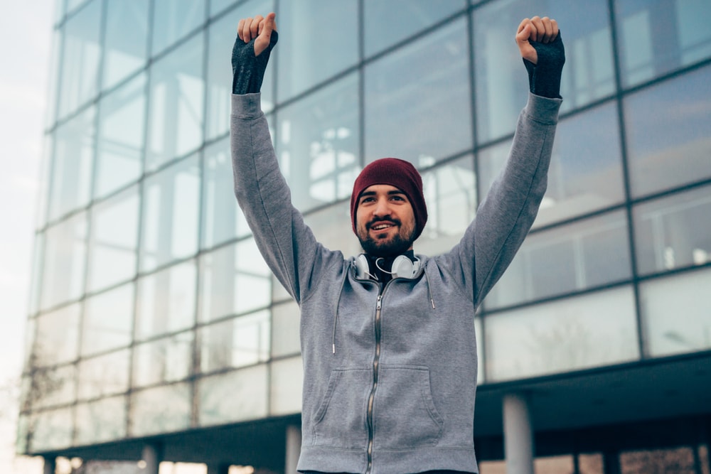 Happy man celebrating after finishing a walk