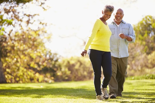 Senior couple fitness walking in a sunny park