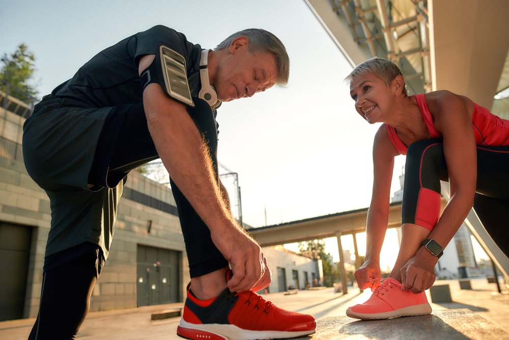 Couple tying shoes getting ready for a fitness walk