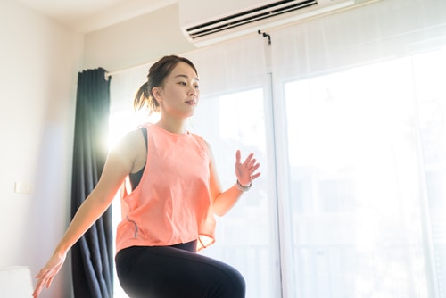 Woman doing active warmup at home in living room