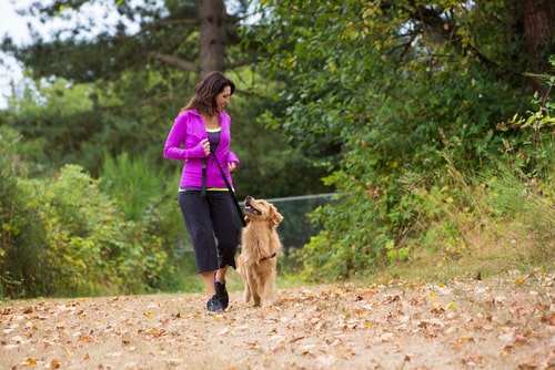 Woman walking dog in the woods