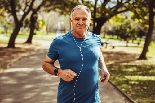 Fit senior man walking for fitness in a park