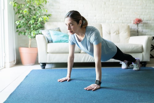Woman doing strength exercises in living room